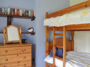 Lydbrook的住宿－Oak Tree Cottage - E5062，一间卧室配有带镜子的双层床和梳妆台