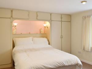 a bedroom with a large white bed with white pillows at The White Cottage in Furness Vale
