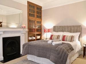 a bedroom with a bed with a fireplace and a mirror at Awelfa - On7 in Aberaeron