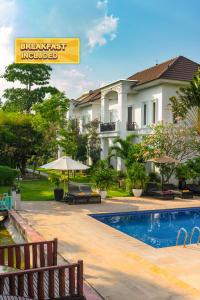 Vimean Sovannaphoum Resort في باتامبانغ: منتجع فيه مسبح ومبنى