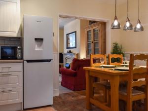 a kitchen and dining room with a white refrigerator and a table at Holly Cottage in Brotton