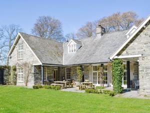 a stone house with a picnic table in the yard at Crogen Coach House - Oqr in Llandrillo