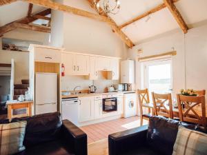 a kitchen with white cabinets and a table and chairs at Goose Cottage- Uk6737 in Lydstep