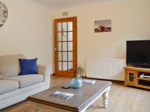 a living room with a couch and a coffee table at Cotton Shore in Inverallochy