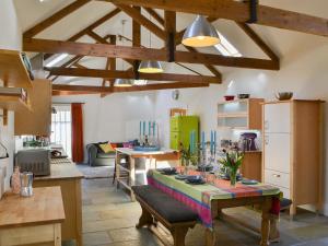 a living room with a table and a kitchen at The Stables in Berwick Hill