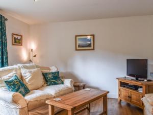 a living room with a couch and a tv at The Nook in Kirkby Lonsdale