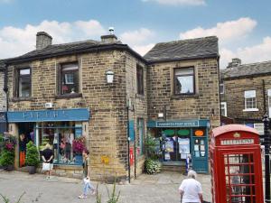 an old brick building with a red telephone booth at Cross Cottage in Haworth