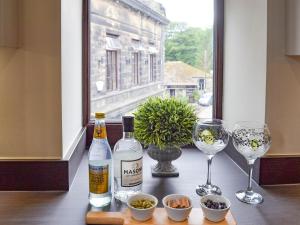 una mesa con dos botellas de vino y dos copas en Cross Cottage, en Haworth