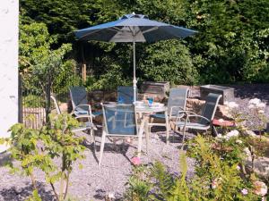 a table and chairs with an umbrella in a garden at Foxes Reach in Trelleck