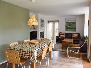 a living room with a table with chairs and a couch at Mussel Cottage in Middleton-on-Sea