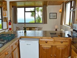 a kitchen with a counter and a window with the ocean at Berlewen - Ukc3536 in Mevagissey