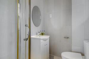 a bathroom with a toilet and a sink and a mirror at 1 Lexham Gardens Hotel in London