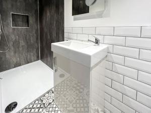 a white bathroom with a sink and a shower at Redmonds Retreat in Chinley