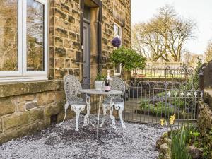 a patio with two chairs and a table with a bottle of wine at Redmonds Retreat in Chinley