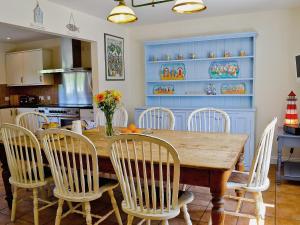 a dining room with a wooden table and chairs at Woodbrook Cottage in Bridport