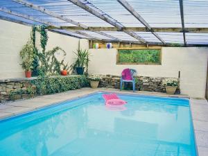 a swimming pool with a pergola and a chair at Drum And Monkey Cottage in Chapel en le Frith