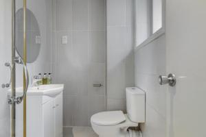 Baño blanco con aseo y lavamanos en 1 Lexham Gardens Hotel, en Londres