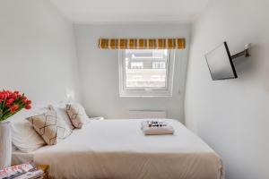 a white bedroom with a large bed and a window at 1 Lexham Gardens Hotel in London