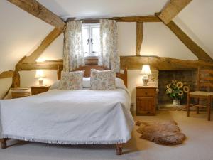 Un dormitorio con una gran cama blanca y una ventana en Hollywall Croft, en Stoke Prior