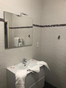 a white bathroom with a sink and a mirror at L'auberge de l'abbaye in Sorde-lʼAbbaye