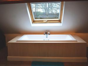 a bath tub in a bathroom with a window at St Albans Church - 28165 in Treherbert
