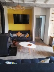 a living room with a couch and a table at Maison de campagne in Paulinet