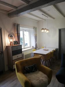 a living room with a table and a couch at Maison de campagne in Paulinet +11 photos