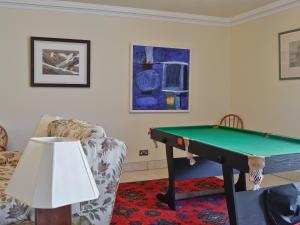 a living room with a pool table and a couch at Waterside in Tighnabruaich