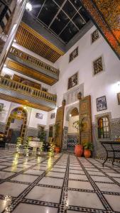 a lobby of a building with a room with ornate ceilings at Riad Green House in Fès