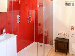 a bathroom with a shower with red tiles at Fionn Croft Lodge in Aultgrishin