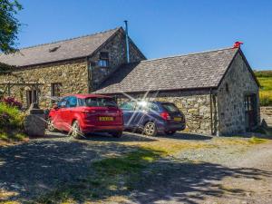 two cars parked in front of a stone building at Clogwyn Bach in Trevor
