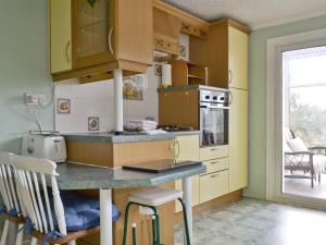 una cocina con armarios amarillos y una barra con sillas en Rock Villas, en Silverdale