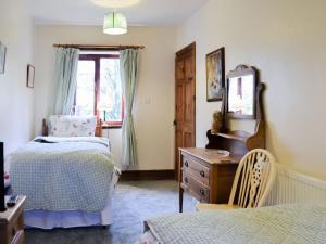 a bedroom with two beds and a dresser and a window at Acorn Barn in Foggathorpe