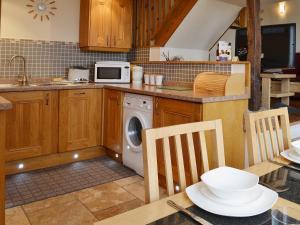 a kitchen with a washing machine and a microwave at The Carriage House in Watermillock
