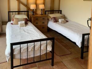 duas camas sentadas uma ao lado da outra num quarto em The Old Carthouse em Steyning