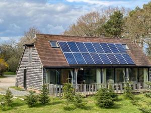 uma casa com painéis solares no telhado em The Old Carthouse em Steyning