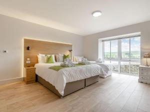 a bedroom with a large bed and a large window at The Stables in Stanhope