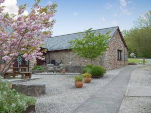 Casa de piedra con jardín con flores en Rook en Broadhempston