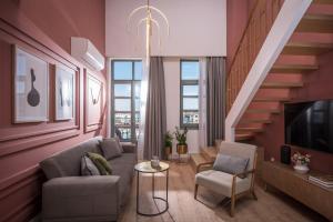 a living room with a couch and chairs and a staircase at The Blossom Collection in Heraklion City Center in Heraklio Town