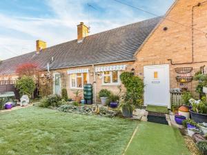 a brick house with a garden in front of it at Wrens Nest in Moreton in Marsh