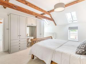 a white bedroom with a bed and a desk at The Granary in Braunston