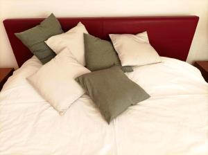 a pile of pillows sitting on top of a bed at Park View Bucharest in Bucharest