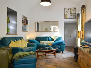 a living room with a blue couch and a table at Bowji in St Just