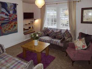 a living room with a couch and a table at Birkenhead Cottage in Hebden Bridge