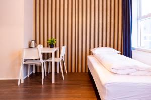 um quarto com uma cama, uma mesa e cadeiras em Westman Islands Inn em Vestmannaeyjar