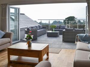 a living room with a patio with couches and a table at Estuary View in Lympstone