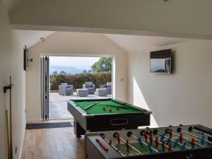 a room with a pool table and a patio at Estuary View in Lympstone