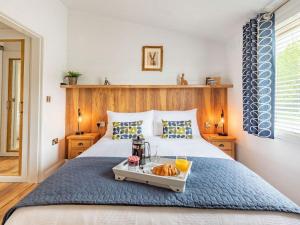 a bedroom with a bed with a tray of food on it at Viburnum Lodge in Willington