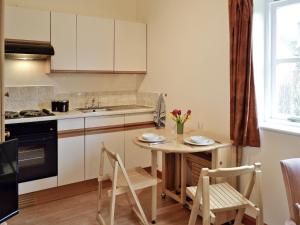 Jasmine Cottage - W41461 في ستورمنستر نيوتن: مطبخ مع طاولة وكراسي ومغسلة