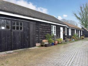 a house with a black garage and a brick driveway at Jasmine Cottage - W41461 in Sturminster Newton